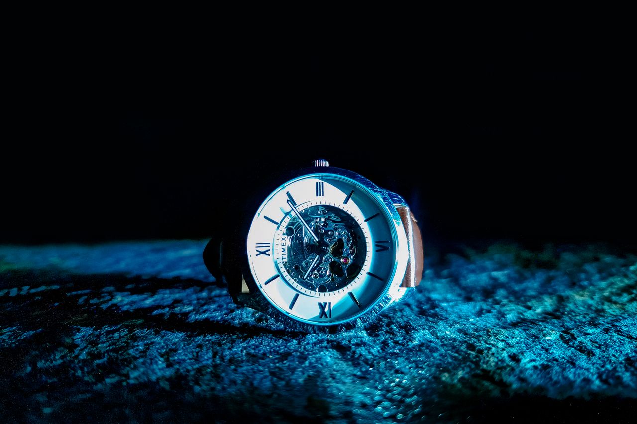 Mastering the First Impression: Your intriguing post title goes here Close-up of a mechanical watch with Roman numerals, illuminated in dramatic lighting.